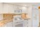 White kitchen features granite countertops and stainless steel appliances at 604 Pennsylvania Ave, Crystal Beach, FL 34681