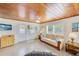 Bright living room features wood ceiling, comfy sofa, and tiled floors at 604 Pennsylvania Ave, Crystal Beach, FL 34681