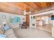 Open living room with view into kitchen and wood ceiling at 604 Pennsylvania Ave, Crystal Beach, FL 34681