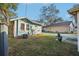 Small backyard featuring a blue home with green grass and access to a parking area at 612 12Th S Ave, St Petersburg, FL 33701