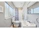 Updated bathroom with large window, wood-look floors, and a tub with tiled shower at 612 12Th S Ave, St Petersburg, FL 33701