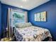 Cozy bedroom with bright blue walls, a comfortable bed, and a window with natural light at 612 12Th S Ave, St Petersburg, FL 33701