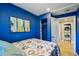 Stylish bedroom with blue walls, patterned bedding, and access to the laundry area at 612 12Th S Ave, St Petersburg, FL 33701