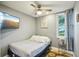Serene bedroom with a ceiling fan, neutral walls, a mounted TV, and a window offering natural light at 612 12Th S Ave, St Petersburg, FL 33701