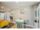Cozy dining area with a white table, woven chairs, and a view into the living room with yellow sofa at 612 12Th S Ave, St Petersburg, FL 33701
