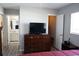 Bedroom with dresser, tv, and access to bathroom and closet at 711 E Brockton Pl, Sun City Center, FL 33573