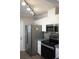 Kitchen boasts stainless steel appliances and white cabinetry at 711 E Brockton Pl, Sun City Center, FL 33573