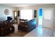 Living room with brown leather sofas, a large window, and tiled floors at 711 E Brockton Pl, Sun City Center, FL 33573