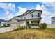 Two-story house with a gray exterior, landscaped lawn, and two-car garage at 8044 Lago Mist Way, Wesley Chapel, FL 33545