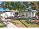 House exterior showcasing landscaping and large shade tree at 9445 Barnstead Ln, Port Richey, FL 34668