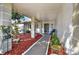 Covered entryway with walkway, mature shrubs, and potted plants at 9445 Barnstead Ln, Port Richey, FL 34668