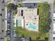 Aerial view showcasing the community pool, shuffleboard courts, building, and ample parking at 9945 47Th N Ave # 206, St Petersburg, FL 33708
