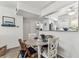 Dining area with seating for four, showcasing modern decor and an open view into the bright, updated kitchen at 9945 47Th N Ave # 206, St Petersburg, FL 33708
