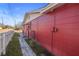 Red house exterior with a walkway and a white picket fence at 10941 Oakdale Ave, Port Richey, FL 34668