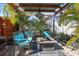 Relaxing patio with fire pit, seating area, and lush tropical landscaping at 10941 Oakdale Ave, Port Richey, FL 34668