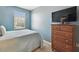 Bedroom with dresser, TV, and light blue walls at 1115 Andrew Aviles Cir, Tampa, FL 33619