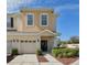 Tan two-story townhome with a two-car garage and landscaping at 1115 Andrew Aviles Cir, Tampa, FL 33619
