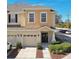 Tan townhome with a two-car garage and manicured landscaping at 1115 Andrew Aviles Cir, Tampa, FL 33619