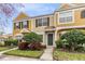 Townhouse exterior with landscaping and gray front door at 1308 Costa Mesa Dr, Wesley Chapel, FL 33543