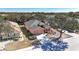 Aerial view of a well-maintained home with a large driveway, landscaping, and mature trees at 1330 Misty Greens Dr, Sun City Center, FL 33573