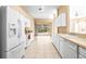 Well-lit kitchen with white cabinets, stainless steel appliances, and a view to the yard at 1330 Misty Greens Dr, Sun City Center, FL 33573