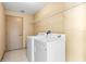 Laundry room with washer, dryer, and overhead shelving for organized storage at 1330 Misty Greens Dr, Sun City Center, FL 33573