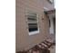 Exterior view of house showing tan walls and a window with storm covering at 14310 N Bayshore Dr, Madeira Beach, FL 33708