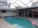 Inviting kidney-shaped pool with a covered patio area at 2046 Winding Oaks Dr, Palm Harbor, FL 34683