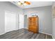 Bedroom with wood-look floors, double doors, and a large wooden storage cabinet at 24745 Portofino Dr, Lutz, FL 33559