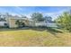 Wide backyard with a patio set with umbrella, BBQ, and bike, enclosed by white fence at 2619 Miriam S St, Gulfport, FL 33711