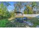 Landscaped backyard with patio furniture under an umbrella surrounded by mature trees at 2619 Miriam S St, Gulfport, FL 33711
