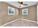 This bedroom features gray tile flooring, two windows with outside views, and a ceiling fan at 2619 Miriam S St, Gulfport, FL 33711