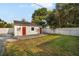 Backyard with detached garage, grassy area, and white fence at 3105 W Spruce St, Tampa, FL 33607