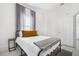 Bright bedroom with metal bed frame, gray blanket, and window with gray curtains at 3105 W Spruce St, Tampa, FL 33607