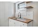 Modern kitchen sink and butcher block countertop with white shaker cabinets at 3105 W Spruce St, Tampa, FL 33607