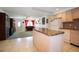 Open kitchen with island, view into living room, and light wood cabinets at 3108 Ash Ct, Dunedin, FL 34698