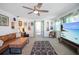 Spacious living room featuring a large TV, comfortable seating, and a view to the backyard at 3108 Ash Ct, Dunedin, FL 34698