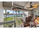 Charming covered balcony with seating overlooking the beautiful waterfront and palm tree-lined landscape at 380 Pinellas Bayway S. # E, Tierra Verde, FL 33715