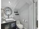 Small bathroom featuring modern fixtures, a round mirror, and a walk-in shower at 380 Pinellas Bayway S. # E, Tierra Verde, FL 33715