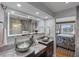 Elegant bathroom with dual vessel sinks, marble countertops, and a large, lighted mirror at 380 Pinellas Bayway S. # E, Tierra Verde, FL 33715