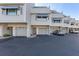Exterior view of townhome featuring private garages, neutral siding, and well-maintained landscaping at 380 Pinellas Bayway S. # E, Tierra Verde, FL 33715