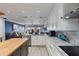 Bright kitchen featuring white cabinetry, stainless steel appliances, and an island with a butcher block countertop at 380 Pinellas Bayway S. # E, Tierra Verde, FL 33715