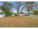 Large front yard with mature trees and a white vinyl fence at 651 Southwest N Blvd, St Petersburg, FL 33703