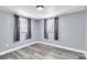 Well-lit bedroom with wood-look flooring and neutral walls at 7014 Ivanhoe Dr, Port Richey, FL 34668