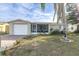 Updated bungalow style home with a screened porch, new landscaping, and a paved driveway at 7014 Ivanhoe Dr, Port Richey, FL 34668