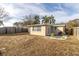 Tan house exterior with a backyard and wooden fence at 7014 Ivanhoe Dr, Port Richey, FL 34668