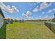Large backyard with lake view, hammock, and fenced perimeter at 9608 Ivory Dr, Ruskin, FL 33573