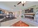 Bright, open-concept living space with stone fireplace, modern ceiling fan, and seamless flow to the kitchen and dining area at 9608 Ivory Dr, Ruskin, FL 33573