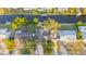 An aerial view shows the home with a boat dock along the canal and lush tropical landscaping at 9665 2Nd N St, St Petersburg, FL 33702