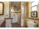 Bathroom featuring tile flooring, a tiled standup shower with glass blocks, and white toilet at 9665 2Nd N St, St Petersburg, FL 33702